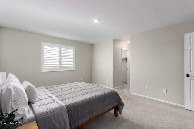 bedroom with light colored carpet and baseboards