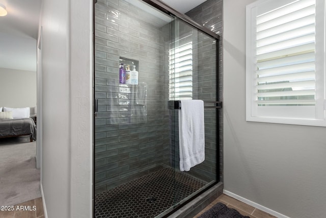 bathroom with baseboards and a stall shower