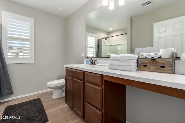 full bath with vanity, wood finish floors, walk in shower, toilet, and visible vents