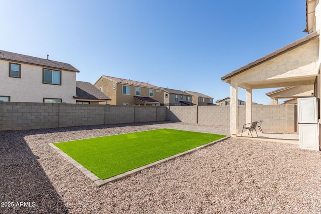 view of yard featuring a fenced backyard, a residential view, and a patio