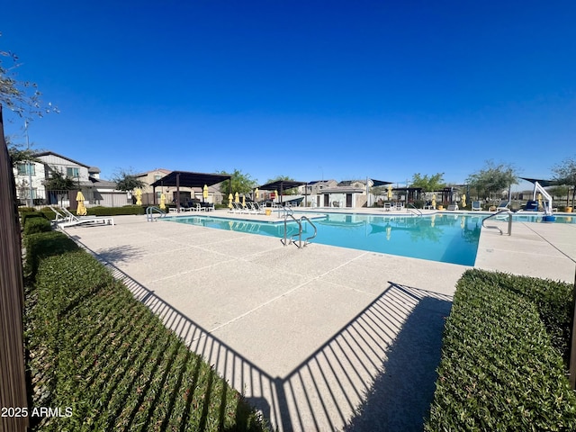pool with a patio area and fence