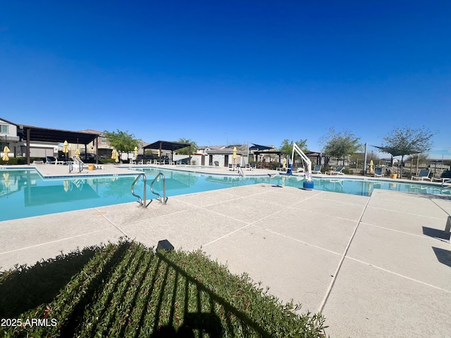 community pool featuring a patio, a pergola, and fence