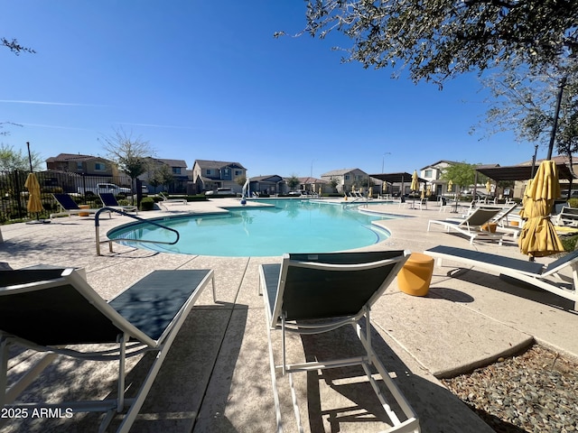 pool featuring a residential view, a patio area, and fence