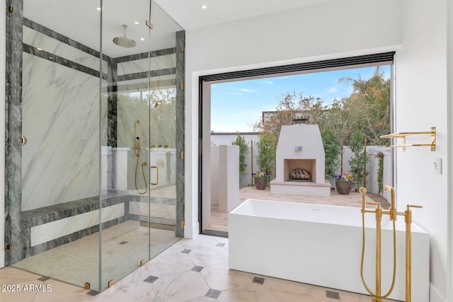 bathroom featuring shower with separate bathtub, exterior fireplace, and a healthy amount of sunlight