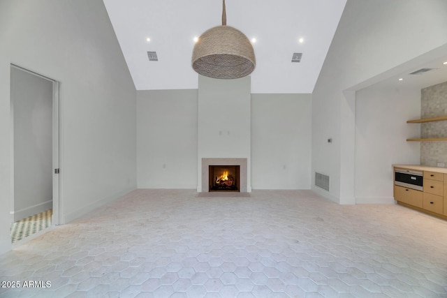 unfurnished living room featuring high vaulted ceiling