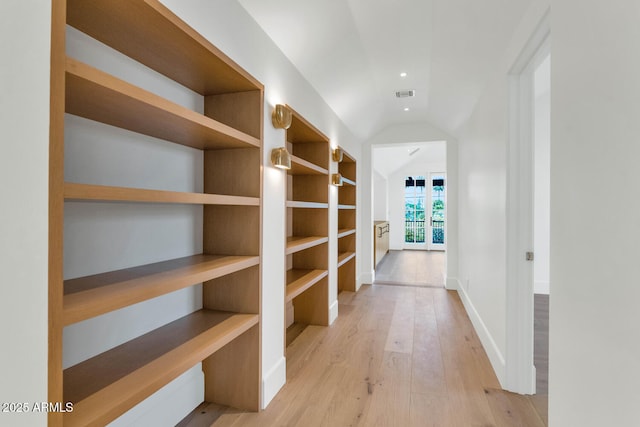 corridor featuring light hardwood / wood-style floors and vaulted ceiling