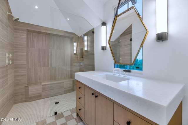 bathroom featuring tiled shower, vanity, and tile patterned flooring