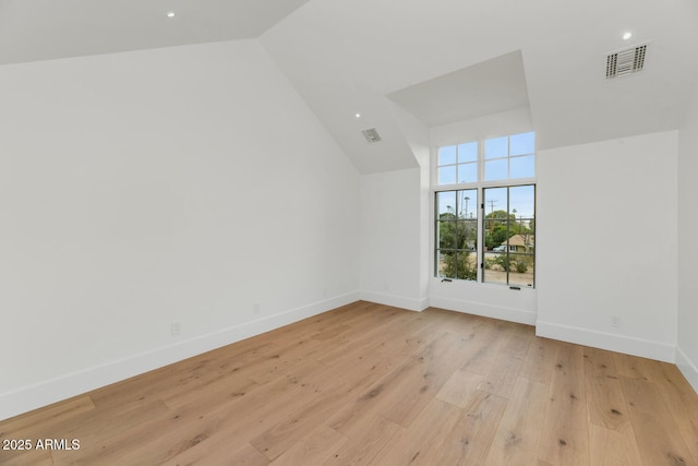 additional living space with vaulted ceiling and light hardwood / wood-style flooring