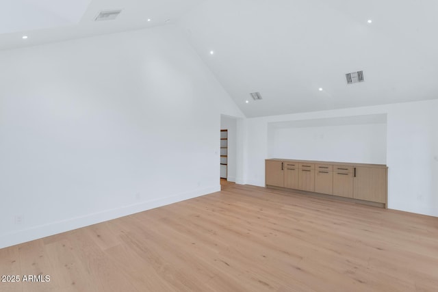 unfurnished living room with high vaulted ceiling and light hardwood / wood-style flooring