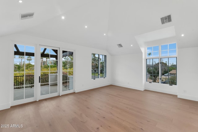 unfurnished living room with high vaulted ceiling and light wood-type flooring