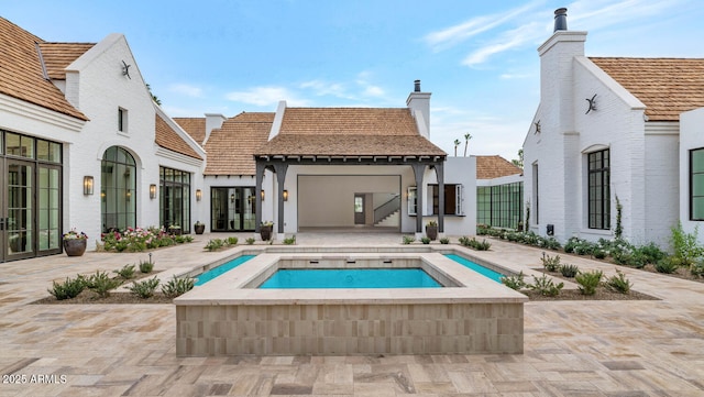 back of house featuring a patio and an in ground hot tub