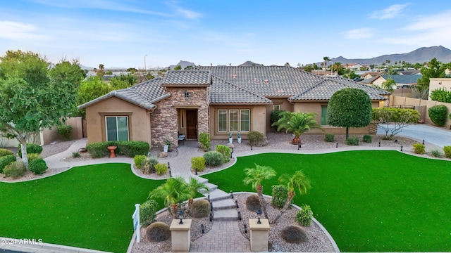 back of property with a mountain view and a yard