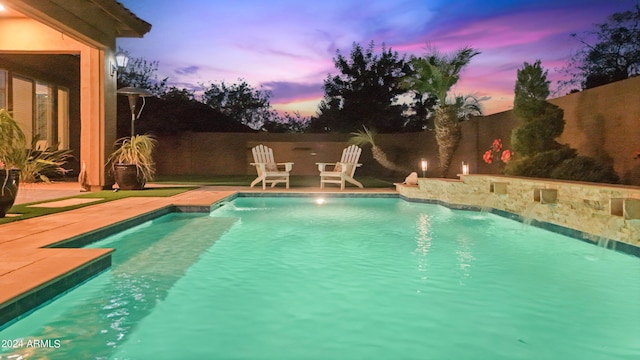 pool at dusk with a patio