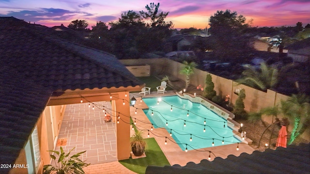 pool at dusk featuring a patio area