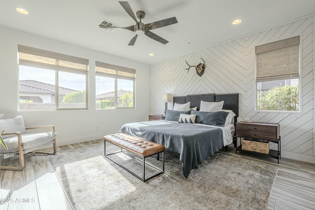 bedroom with ceiling fan and wooden walls