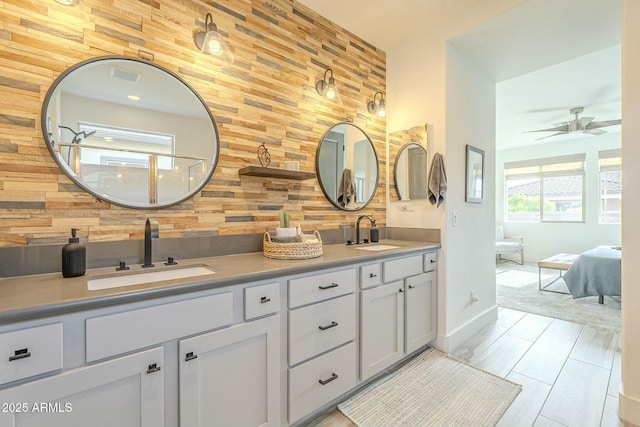 bathroom featuring ceiling fan, vanity, and wooden walls