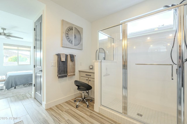 bathroom with vanity, ceiling fan, and a shower with door