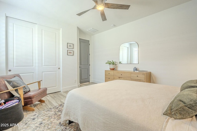 bedroom with ceiling fan, a closet, and light hardwood / wood-style flooring