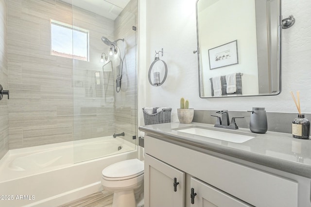 full bathroom featuring toilet, vanity, and tiled shower / bath