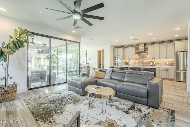 living room with ceiling fan and light wood-type flooring