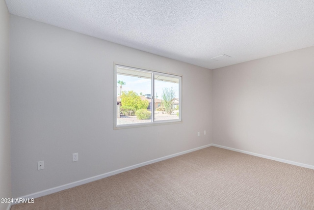 carpeted spare room with a textured ceiling