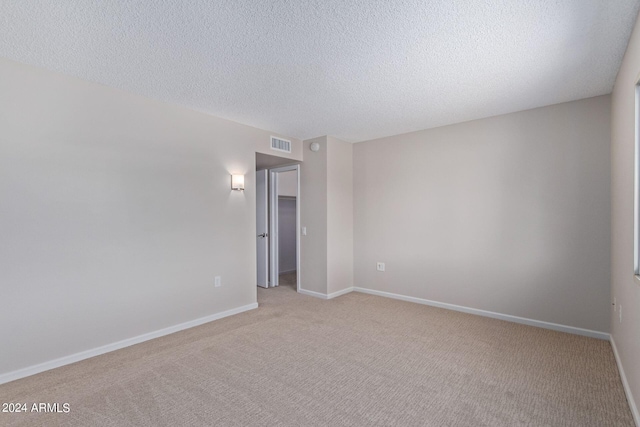 carpeted spare room with a textured ceiling