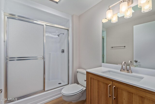 bathroom with walk in shower, toilet, and vanity