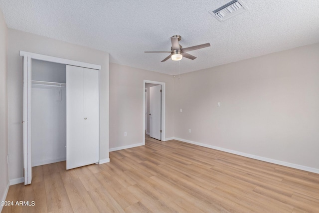 unfurnished bedroom featuring a closet, ceiling fan, a textured ceiling, and light hardwood / wood-style flooring