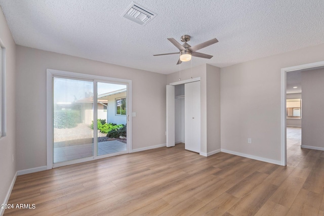 unfurnished bedroom featuring visible vents, light wood-style flooring, a ceiling fan, access to outside, and baseboards