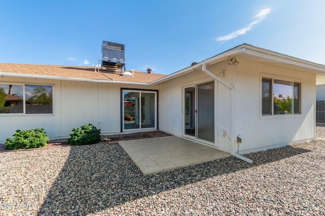 back of property featuring a patio area and roof with shingles