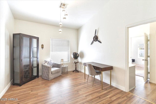 sitting room featuring a wealth of natural light and light hardwood / wood-style flooring