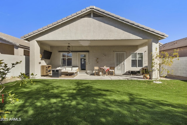 rear view of property featuring an outdoor living space, a patio area, and a lawn