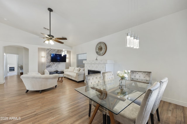 dining space with lofted ceiling, ceiling fan, and light wood-type flooring