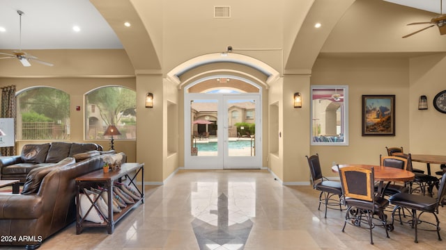 interior space featuring ceiling fan, a high ceiling, and french doors