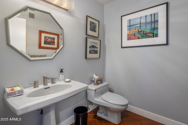 1209 W Golden Ln, Phoenix, AZ 85021 - half bath featuring visible vents, baseboards, toilet, and wood finished floors