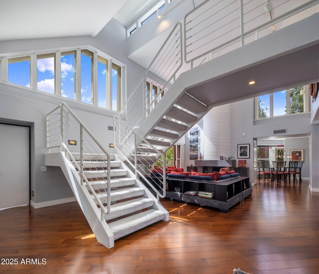 1209 W Golden Ln, Phoenix, AZ 85021 - stairway with baseboards, a high ceiling, wood-type flooring, and visible vents