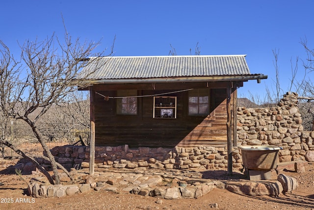 view of property exterior with an outbuilding and metal roof