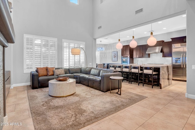 tiled living room featuring a towering ceiling