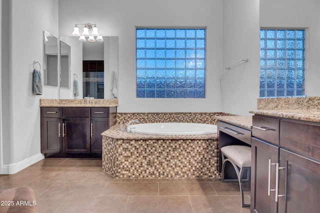 bathroom featuring vanity, tiled bath, and tile patterned flooring