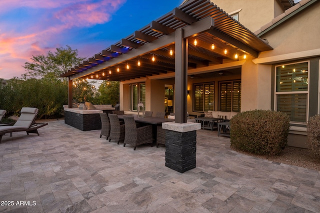 patio terrace at dusk featuring a pergola and an outdoor living space with a fire pit