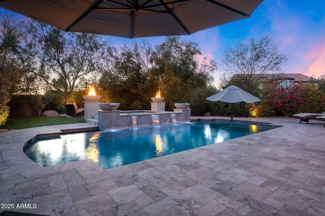 pool at dusk featuring an in ground hot tub, a patio area, pool water feature, and area for grilling