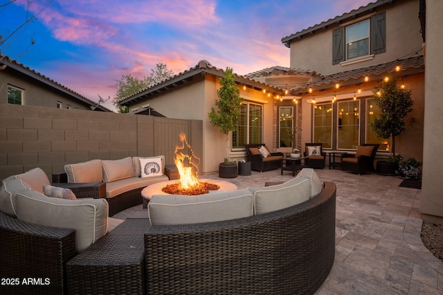 patio terrace at dusk featuring an outdoor living space with a fire pit