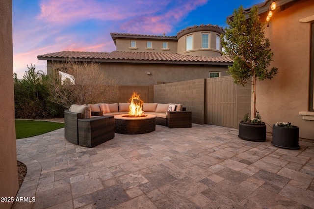 patio terrace at dusk featuring an outdoor living space with a fire pit