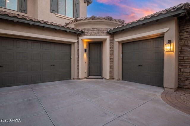 view of garage at dusk