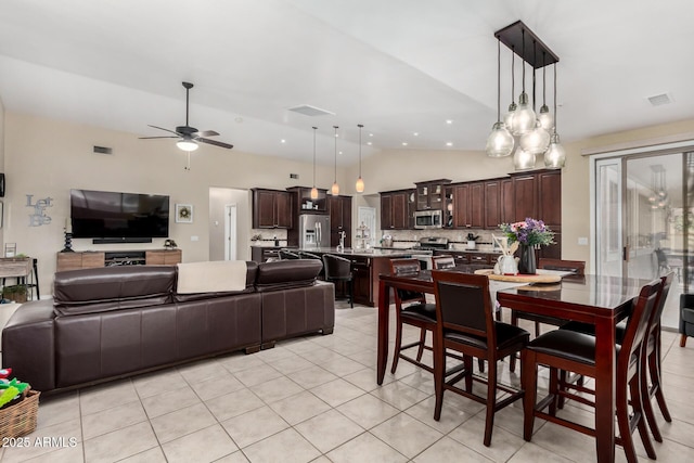 tiled dining space featuring lofted ceiling and ceiling fan