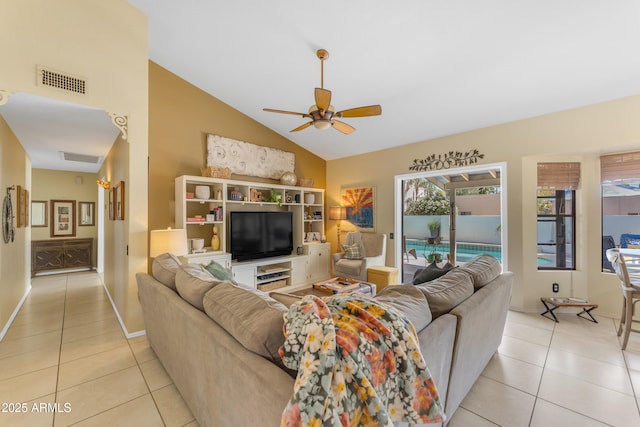 living room featuring light tile patterned floors, ceiling fan, visible vents, baseboards, and vaulted ceiling