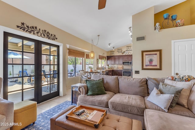 living area with light tile patterned flooring, lofted ceiling, a ceiling fan, visible vents, and french doors