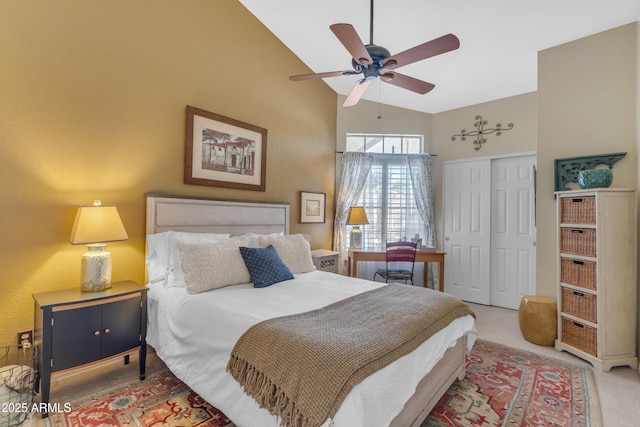 carpeted bedroom with a closet, high vaulted ceiling, and a ceiling fan