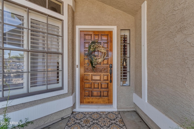 property entrance with a porch and stucco siding