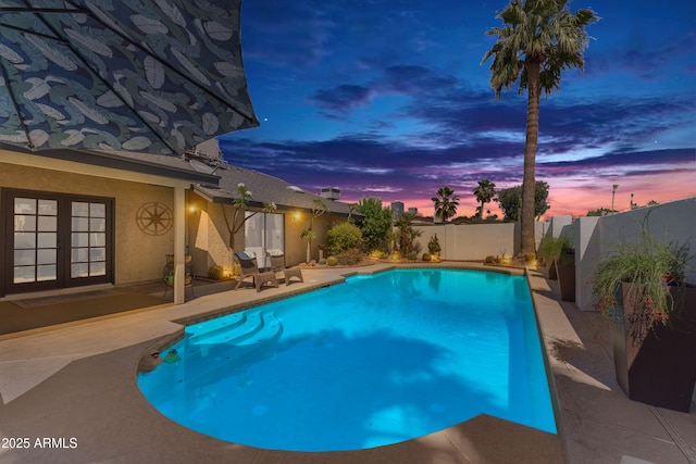view of swimming pool with french doors, a fenced backyard, a patio, and a fenced in pool